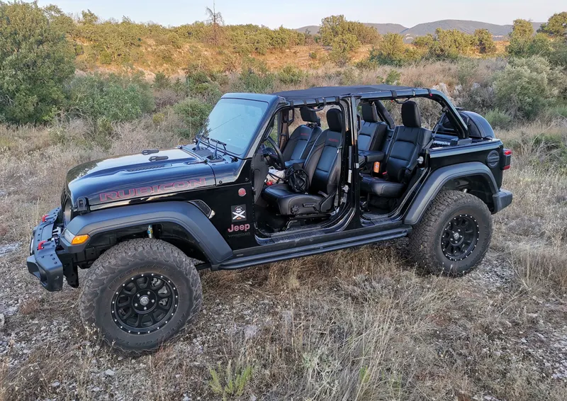Schwarzer Jeep Wrangler ohne Türen in der Heidelandschaft der Ardèche