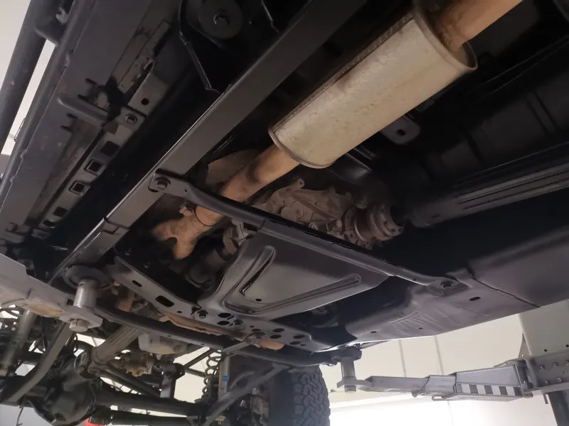 Unterboden eines Jeeps auf der Hebebühne mit Auspuff und Rahmen