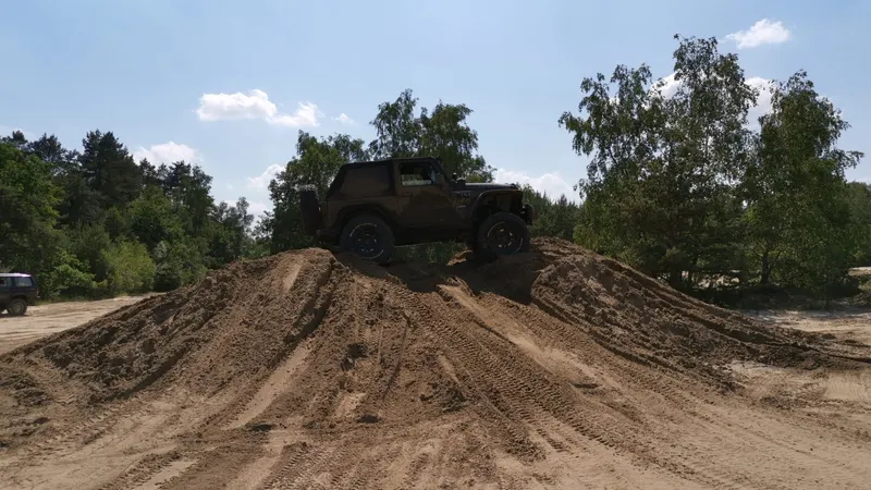 Jeep steht oben auf einem Sandhügel