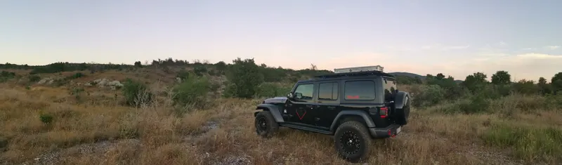 Jeep Wrangler in weiter Buschlandschaft in der Abenddämmerung