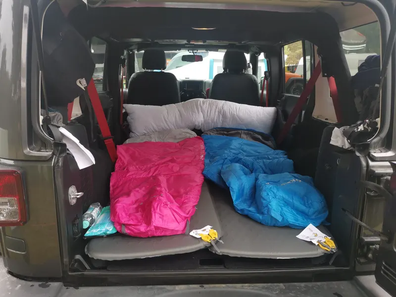 Laderaum eines Jeeps mit Schlafsäcken und Isomatten für die Übernachtung