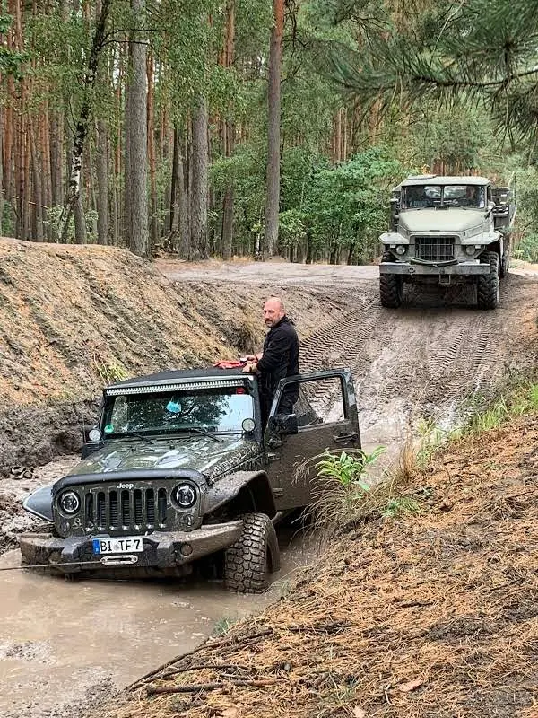 Zwei Jeeps in einer sandigen Senke im Wald
