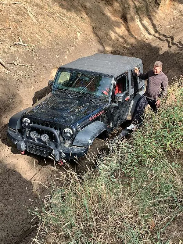 Jeep in einem engen, steilen Hohlweg, daneben ein Teilnehmer