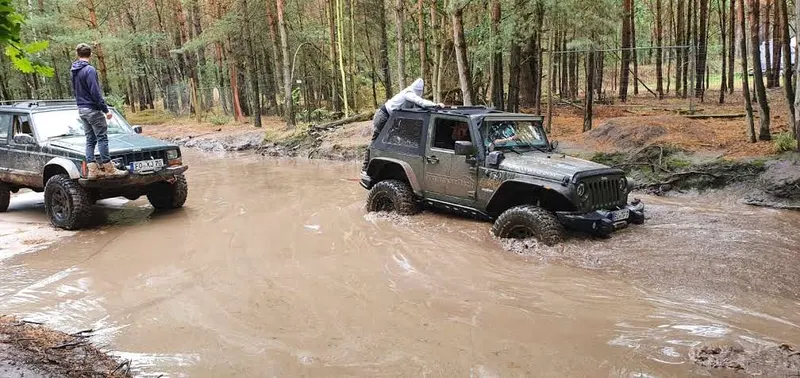 Jeeps mit Teilnehmern auf dem Dach in einer Wasserstelle