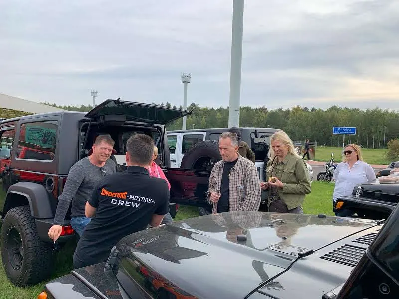 Teilnehmer unterhalten sich zwischen geparkten Jeeps