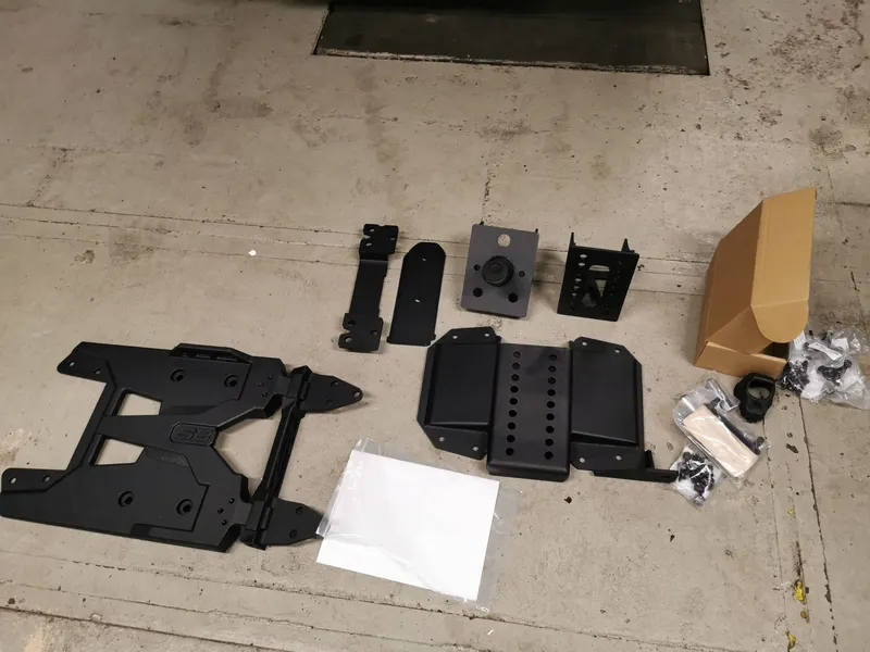 Teile für einen Reserverad-Halter auf dem Werkstattboden ausgelegt