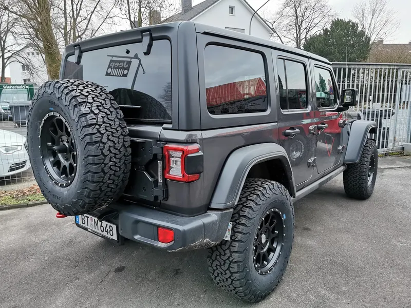 Heck eines grauen Jeep Wrangler mit großem Reserverad