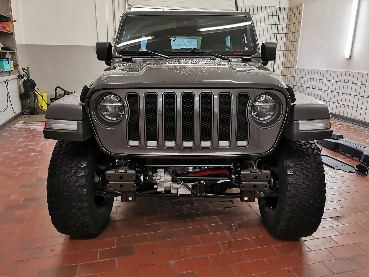 Front eines grauen Jeep Wrangler in der Werkstatt