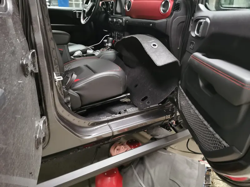 Innenraum eines Jeeps mit ausgebautem Sitz während der Arbeiten