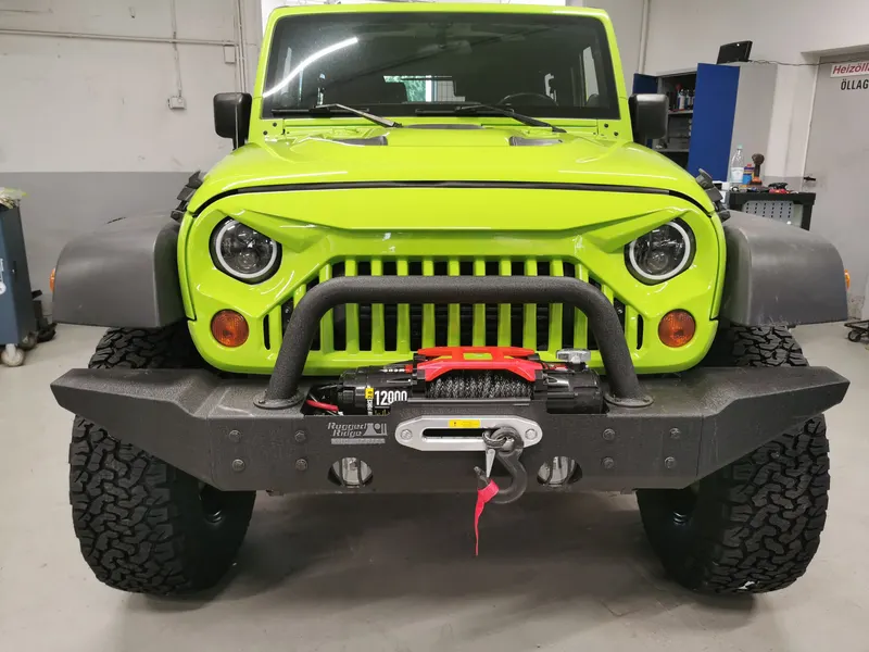 Front eines hellgrünen Jeep Wrangler mit Stahlstoßstange und Seilwinde
