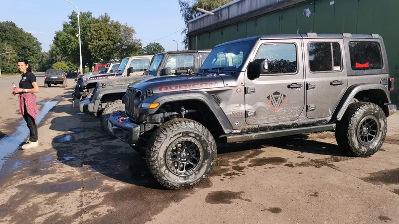 Mehrere Jeep Wrangler in einer Reihe, daneben eine Teilnehmerin