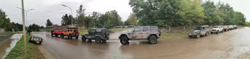 Panorama: Jeeps auf einer langen Straße am Waldrand