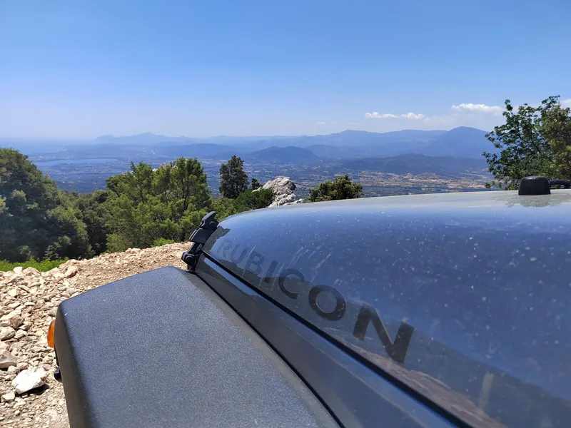 Blick über die Motorhaube eines Jeeps auf die Berge Sardiniens