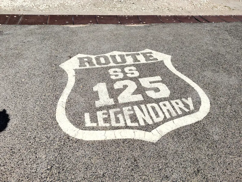 Schriftzug „Route SS 125 Legendary“ auf dem Asphalt