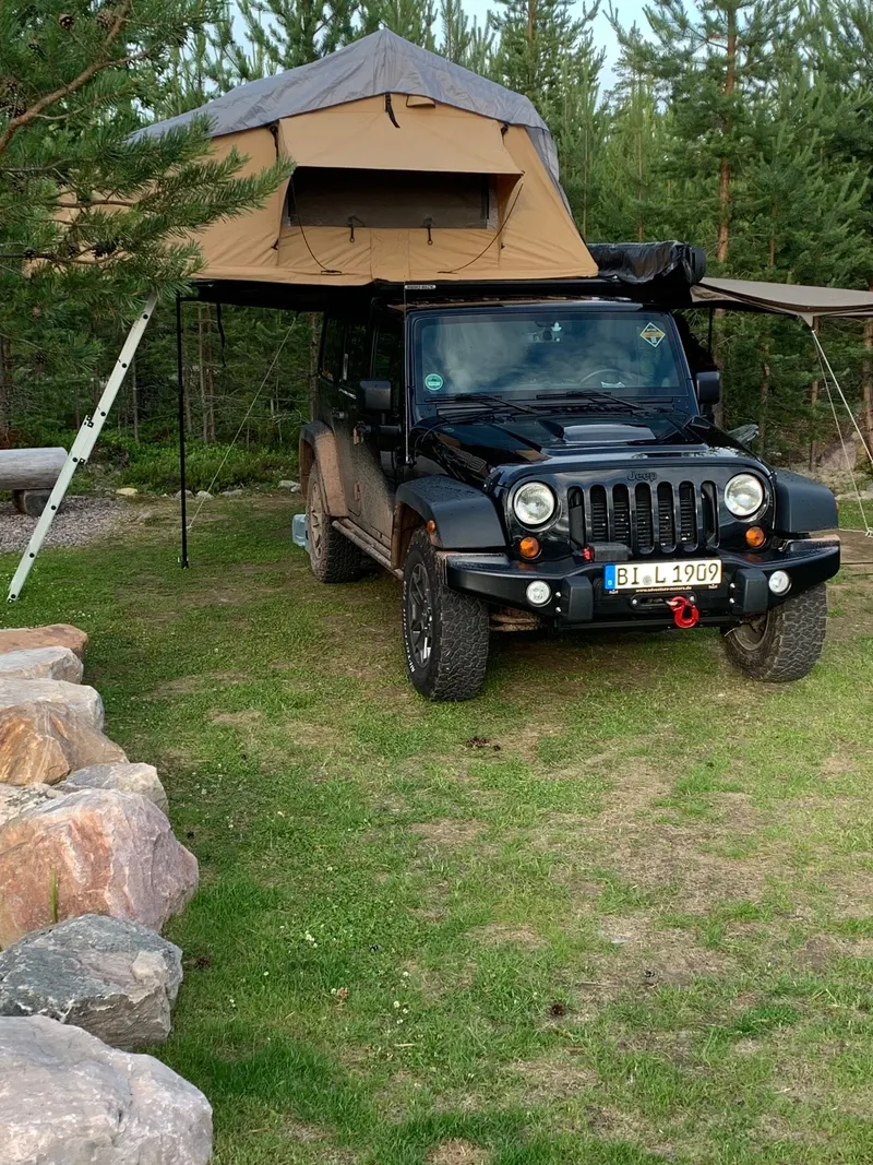 Jeep Wrangler mit aufgebautem Dachzelt und Markise