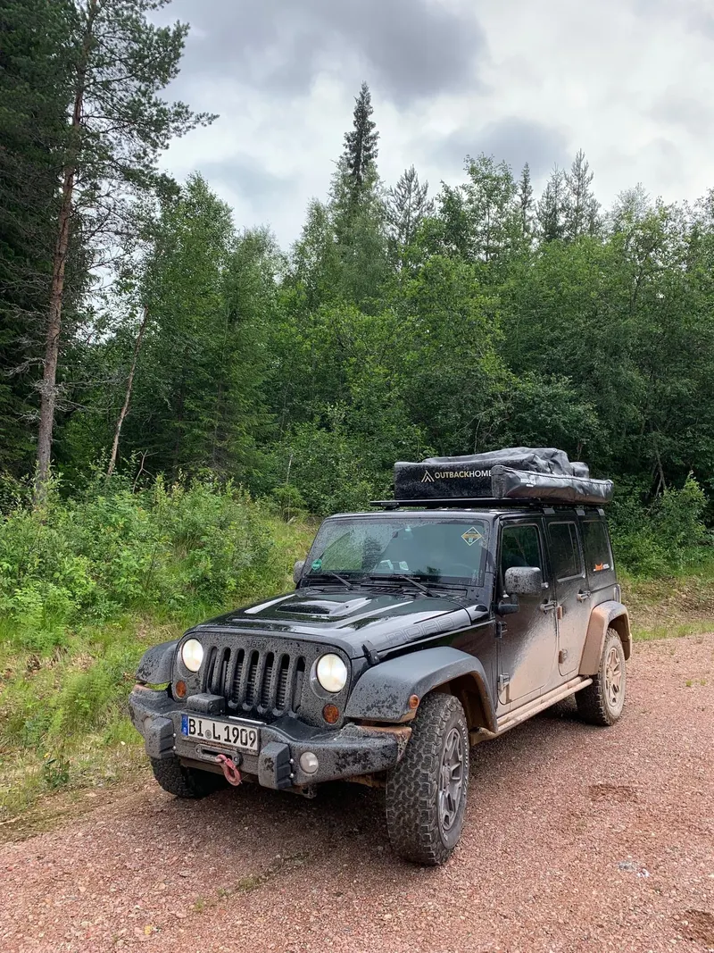 Jeep Wrangler mit Dachzelt auf einem Waldweg