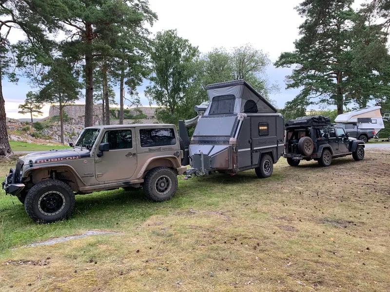 Jeep Wrangler mit Offroad-Wohnwagen auf einem Campingplatz